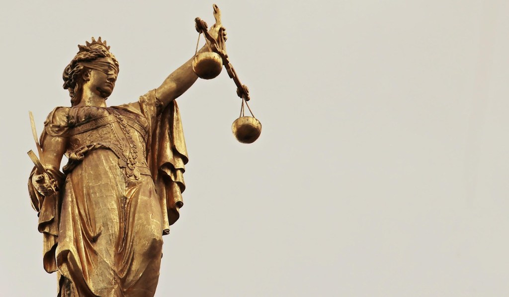 A golden figure of Justice - blindfolded and holding golden scales.